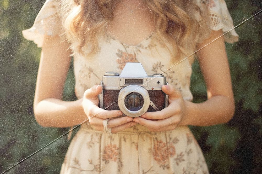 Woman holding film camera, fold paper texture
