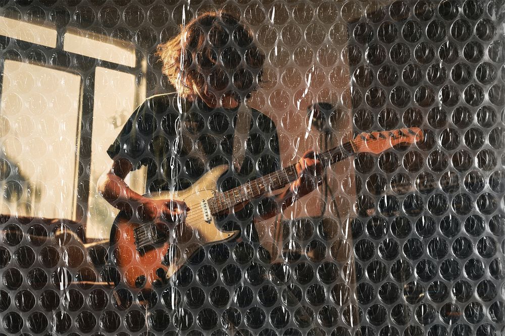 Young man playing guitar, plastic bubble wrap texture