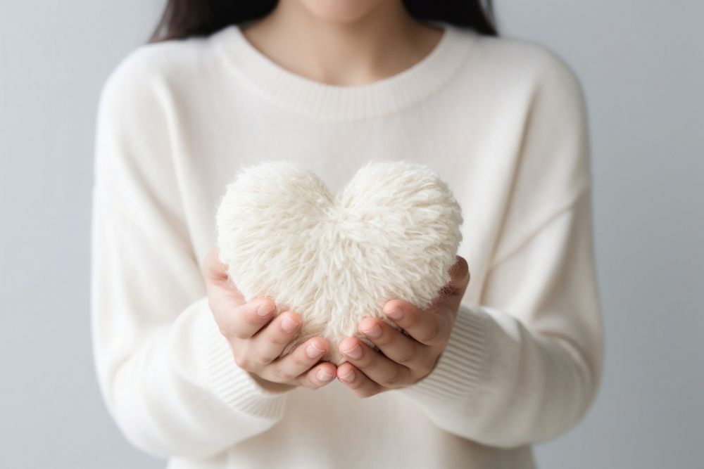 People hold heart sweater white love. 