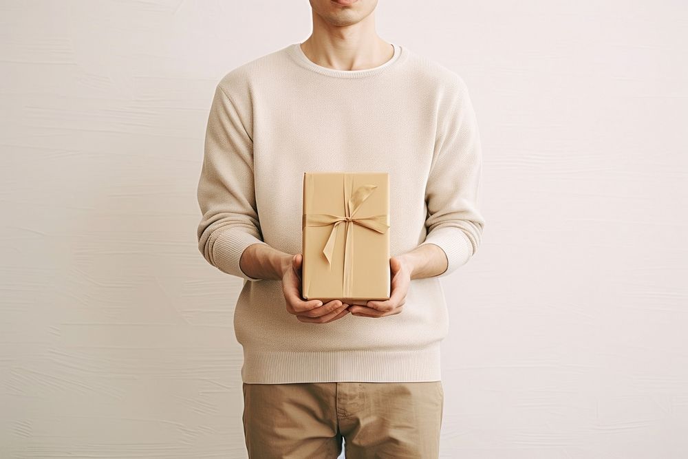 Man holding gift box sweater celebration anniversary. AI generated Image by rawpixel.