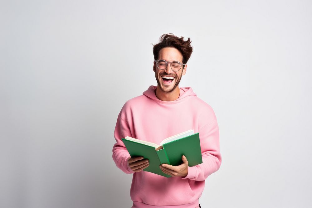 Man hold textbook pink read beaming shiny smile enjoy wear spectacles green pullover laughing portrait reading. AI generated…