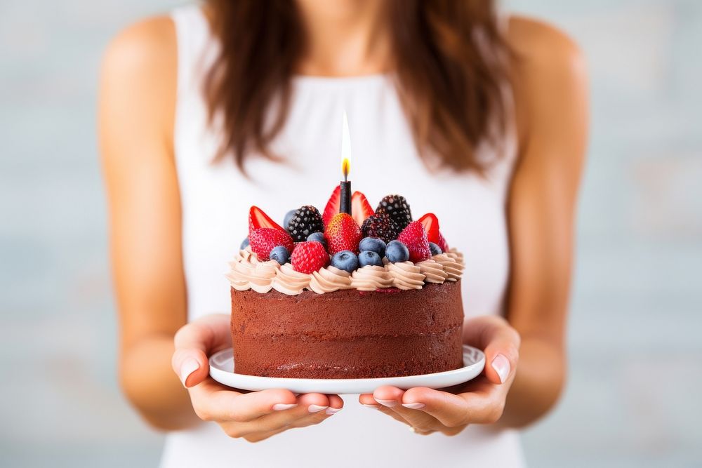 Birthday cake dessert holding berry. 