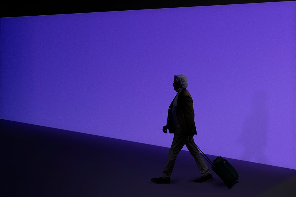Man walking near purple wall
