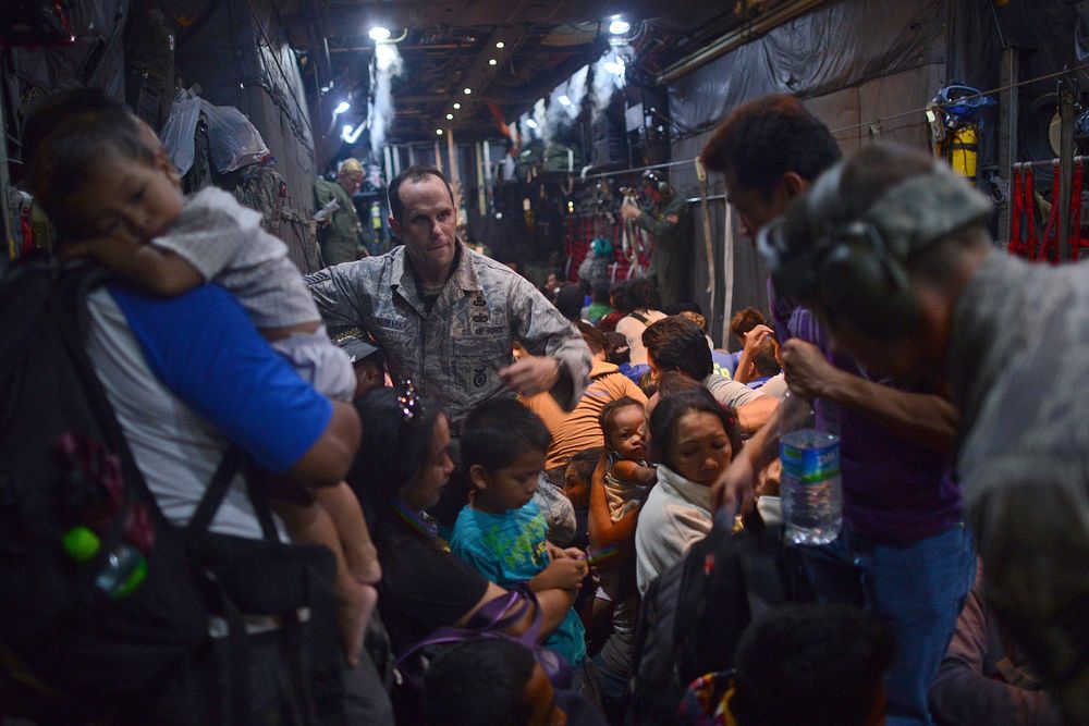 U.S. Airmen help residents of Tacloban, Philippines, as they board an Air Force C-130H Hercules aircraft at the city's…