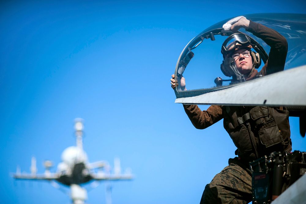 U.S. Marine Corps Cpl. Michael Mathisen, with Marine Fighter Attack Squadron (VMFA) 312, cleans the canopy of an F/A-18C…