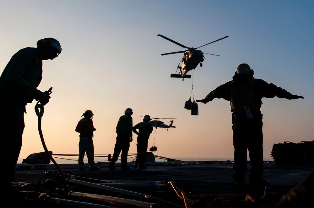 U.S. Sailors direct an MH-60S Seahawk helicopter assigned to Helicopter Sea Combat Squadron (HSC) 7 to the flight deck of…