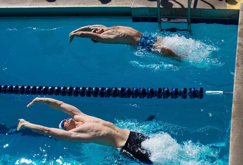 International service members begin the mens 50-meter backstroke event during a swim meet as part of Rim of the Pacific…