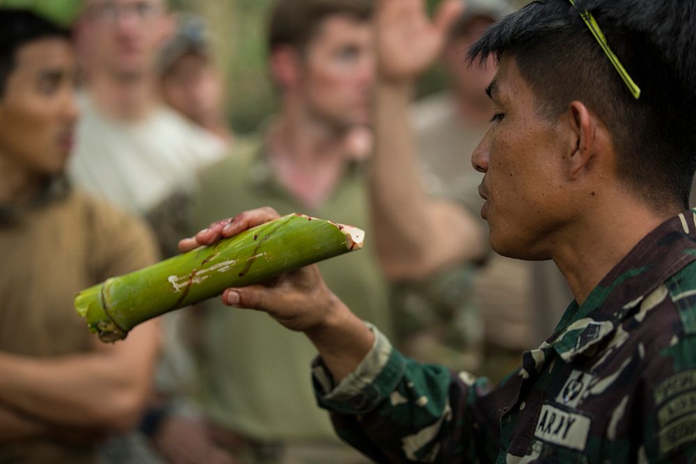 Philippine Army Tech. Sgt. Riden A. Dumalig, right, drinks cobra blood May 5, 2014, during jungle survival training for…