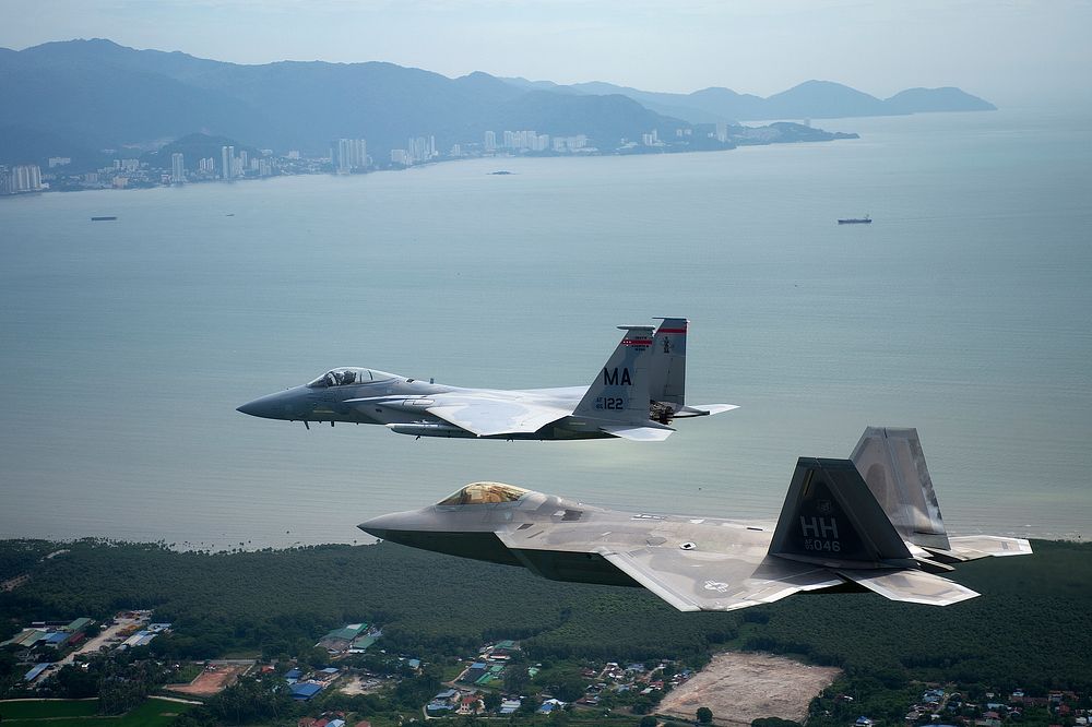 A U.S. Air Force F-22 Raptor aircraft, front, assigned to the 154th Wing, Hawaii Air National Guard and an F-15 Eagle…