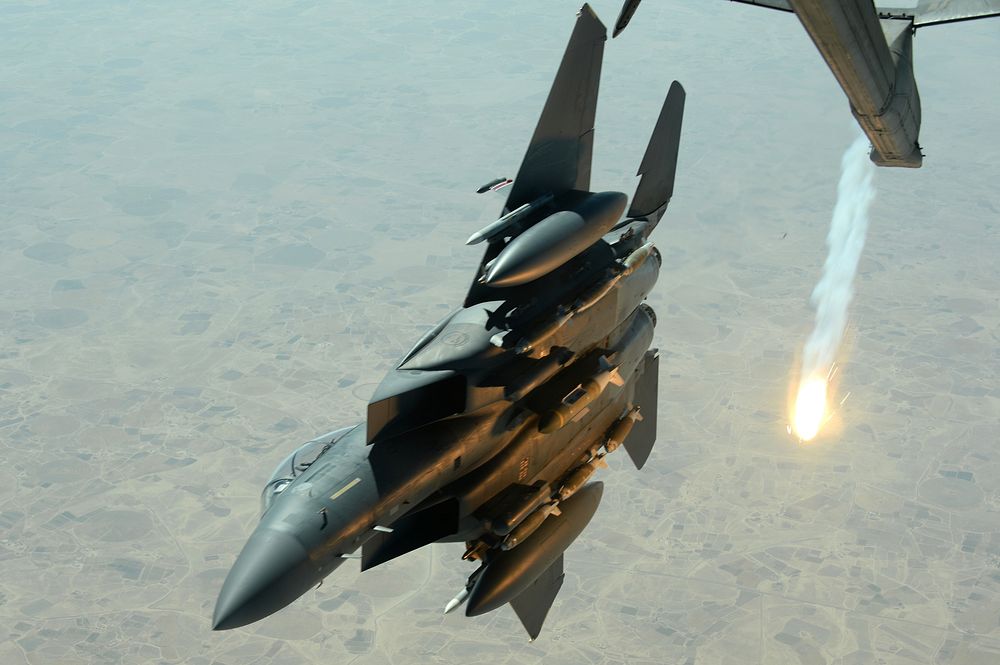 A U.S. Air Force F-15E Strike Eagle pops a flare while departing after refueling with a USAF KC-10 Extender over Southwest…