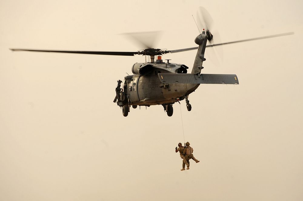 U.S. Air Force pararescuemen are hoisted into an HH-60G Pave Hawk helicopter during training at an undisclosed location in…