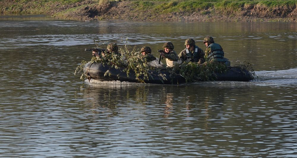 Romanian Soldiers ride across the Mures River as they suppress enemy fire during Exercise Dragoon Crossing – Romania, near…