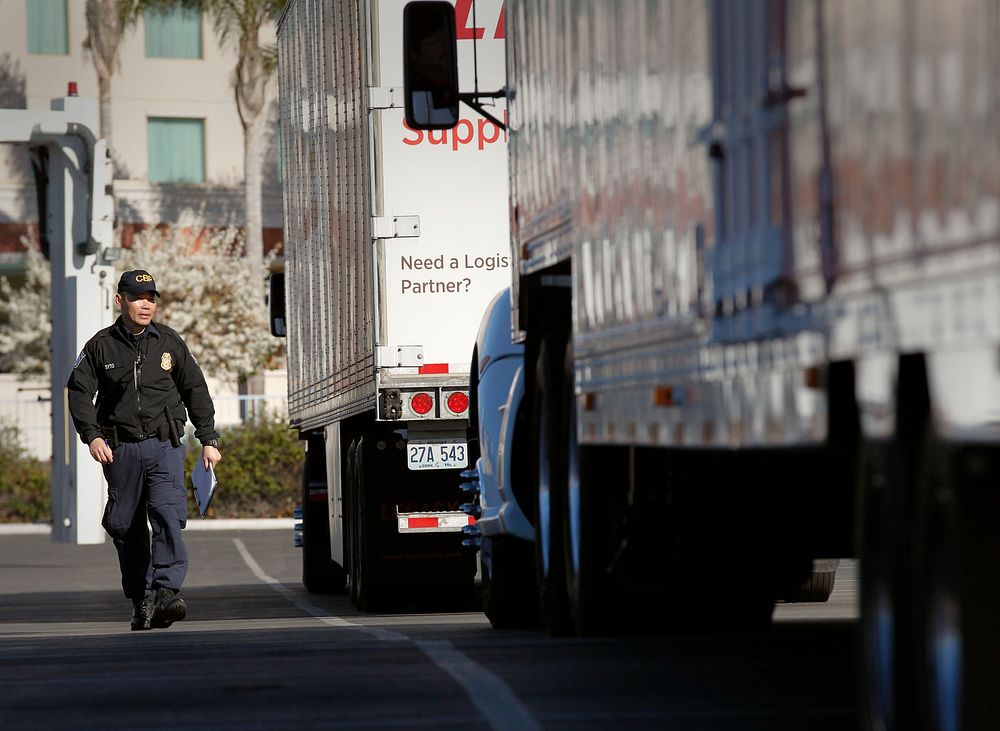 U.S. Customs and Border Protection officer Alan Syto prepares a line of trucks for non-intrusive inspections x-rays outside…