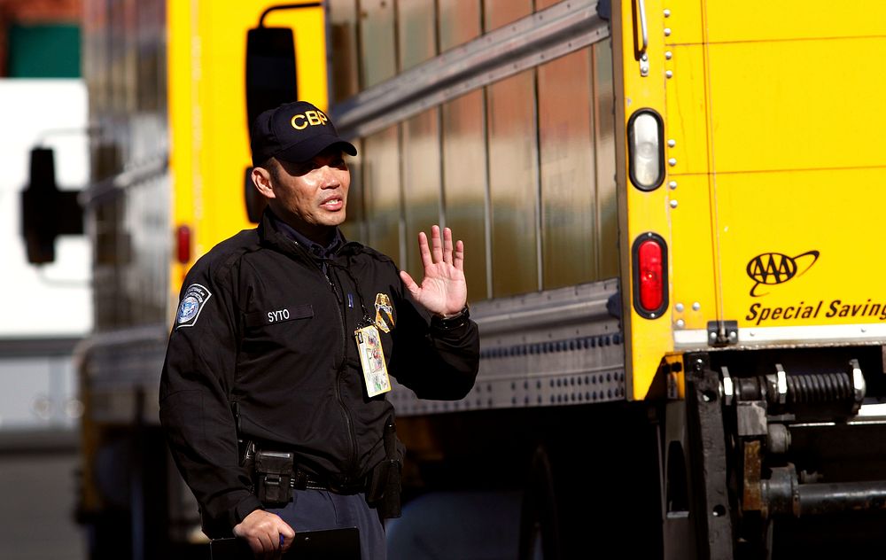 U.S. Customs and Border Protection officer Alan Syto gestures to a truck driver making a delivery to Levi's Stadium as a…
