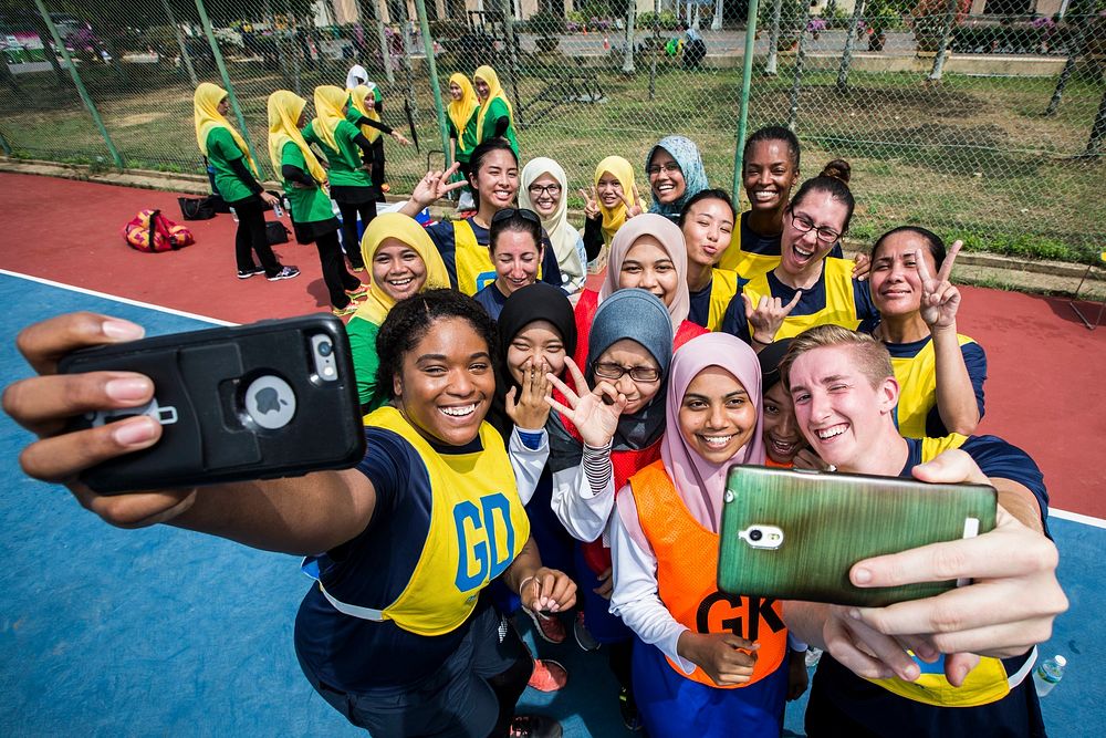 U.S. Navy personnel and students from the International Islamic University of Malaysia take group photos on their phones…