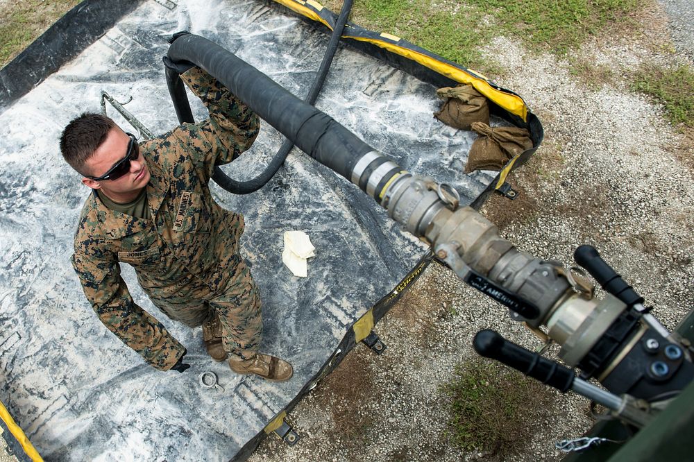 U.S. Marines Corps Pfc. Quinton Jones, assigned to the 9th Engineer Support Battalion, refuels a SIXCON fuel tank from Naval…