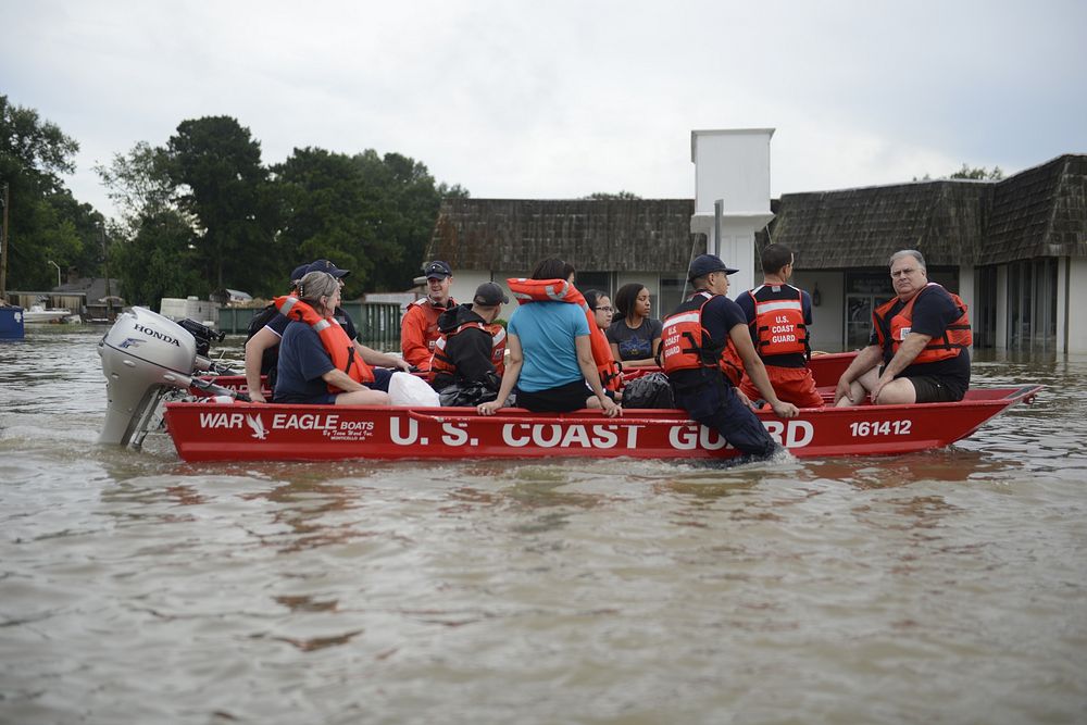 U.S. Coast Guard members rescue locals from flood water on their flat-bottom boats in Baton Rouge, Louisiana, Aug. 14, 2016.