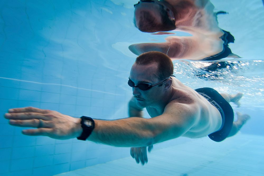 U.S. Navy Petty Officer 2nd Class Christopher Sabella, Patrol Squadron Four Seven, swims laps at the pool facility on Camp…