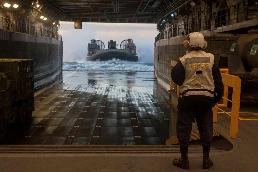 A Sailor on the USS Mesa Verde (LPD 19) directs a landing craft air cushioned vehicle aboard the USS Mesa Verde (LPD 19)…