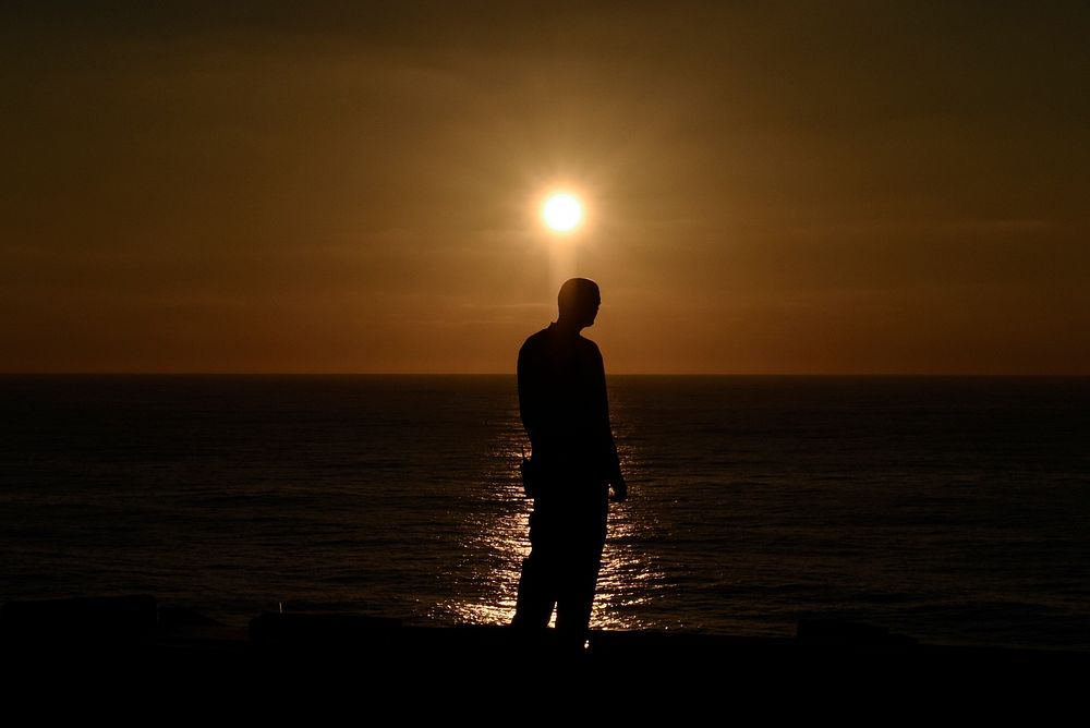 U.S. Navy Airman Dennis Martinovich watches the sunset on the flight deck aboard the aircraft carrier USS Theodore Roosevelt…