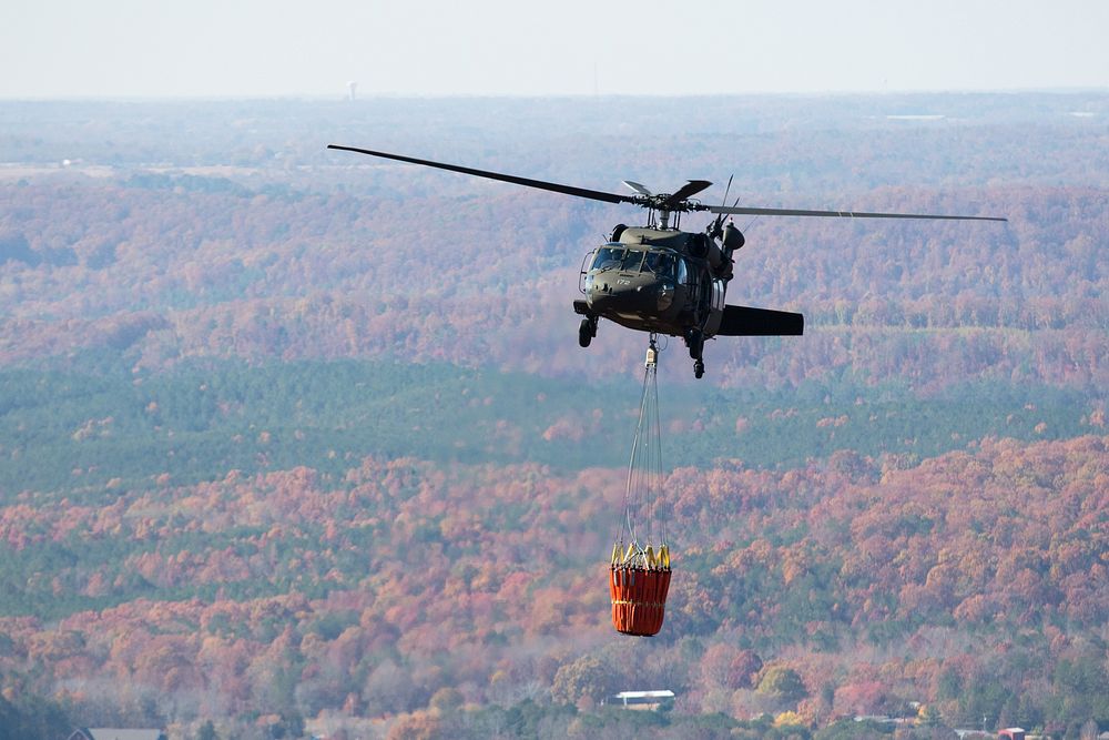 An Alabama National Guard UH-60 Black Hawk helicopter with Bambi bucket assembly provides aerial water delivery, at the…