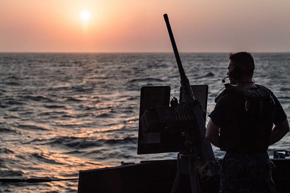 U.S. Navy Fire Controlman 3rd Class Hunter Scholl mans a .50-caliber machine gun aboard the guided-missile destroyer USS…