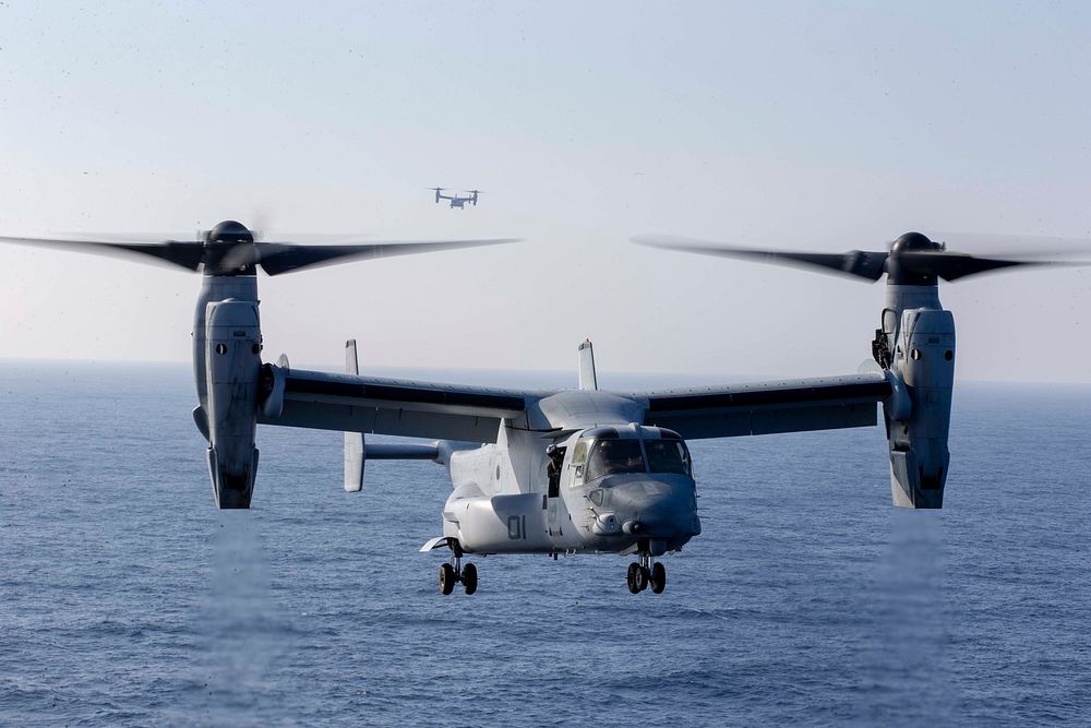 U.S. Marine Corps MV-22B Ospreys with the 22nd Marine Expeditionary Unit prepare to land on the flight deck of the USS…