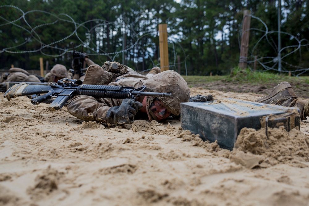 U.S. Marine Corps recruit John Krulder, assigned to Fox Company, 2nd Recruit Training Battalion, low-crawls during the…