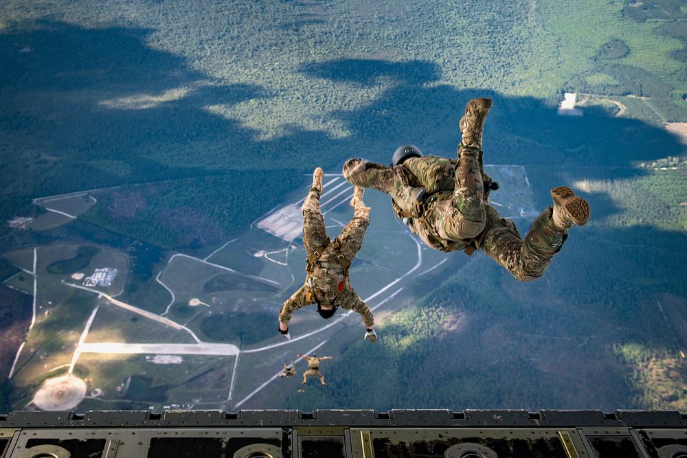 U.S. Air Force Pararescuemen with the 38th Rescue Squadron jump from the back of an HC-130J Combat King II aircraft over…