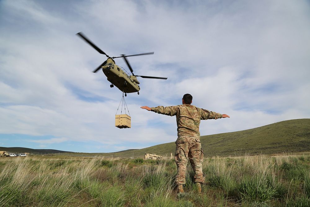 U.S. Army Staff Sgt. Keith Beardsley, an Air Assault instructor with the Phantom Warrior Academy, signals a CH-47 Chinook…