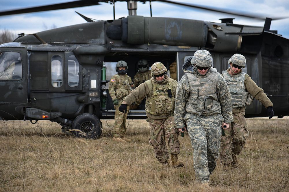U.S. Soldiers, assigned to Public Health Command Europe, collect a simulated causality from a UH-60 Blackhawk, operated by…