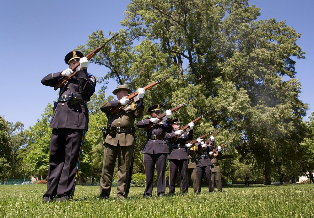 A contingent of law enforcement officers fire their rifles during a gun salute at the conclusion of the National Peace…