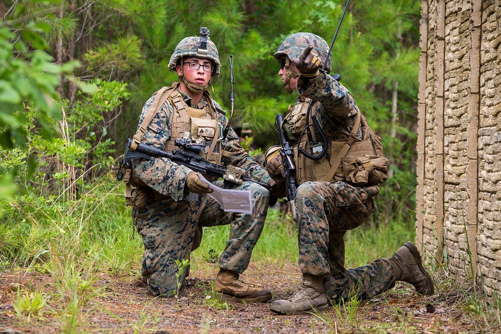 After studying a map, a Marine points in the direction of the objective during a Marine Combat Readiness Exercise at Camp…