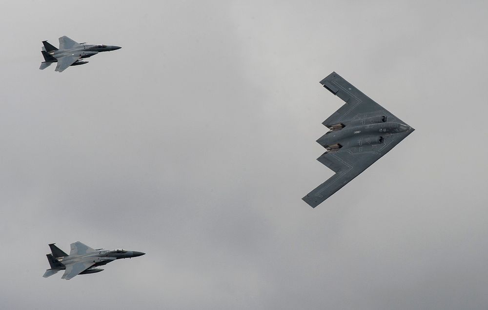 A U.S. Air Force B-2 Stealth Bomber and two F-15 Strike Eagle aircraft fly past spectators during the 2017 Royal…