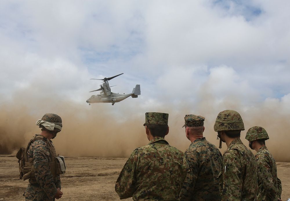 U.S. Marines and members of the Japan Ground Self-Defense Force watch as the MV-22 Osprey takes off Aug. 18, 2017, in…