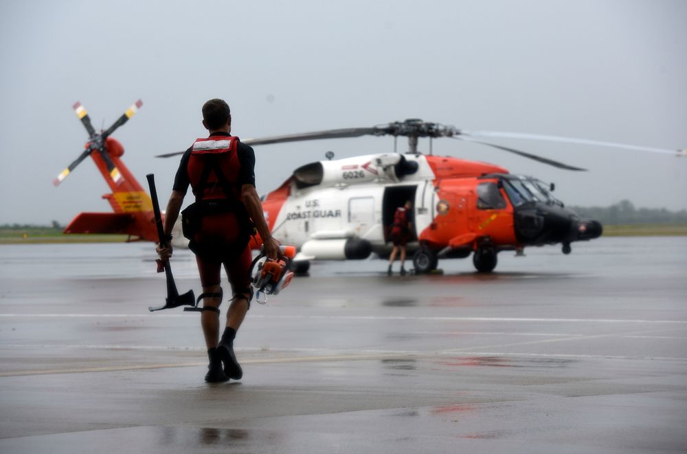 A U.S. Coast Guard rescue swimmer walks toward an MH-60 Jayhawk helicopter at Air Station Houston Aug. 27, 2017.