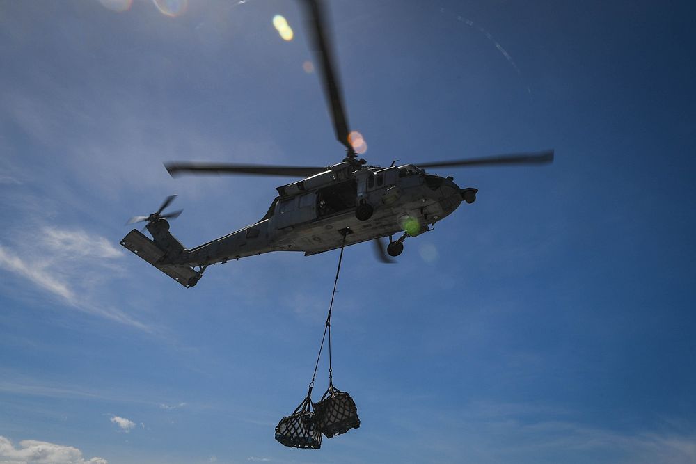 An MH-60S Sea Hawk helicopter, assigned to the "Sea Knights" of Helicopter Sea Combat Squadron (HSC) 22, delivers pallets to…