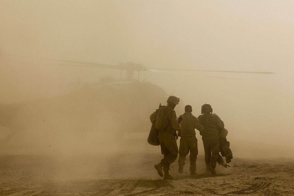Fellow U.S. Marines escort Sgt. Michael Medinasanchez to a UH-60 Black Hawk helicopter during his medical evacuation in the…