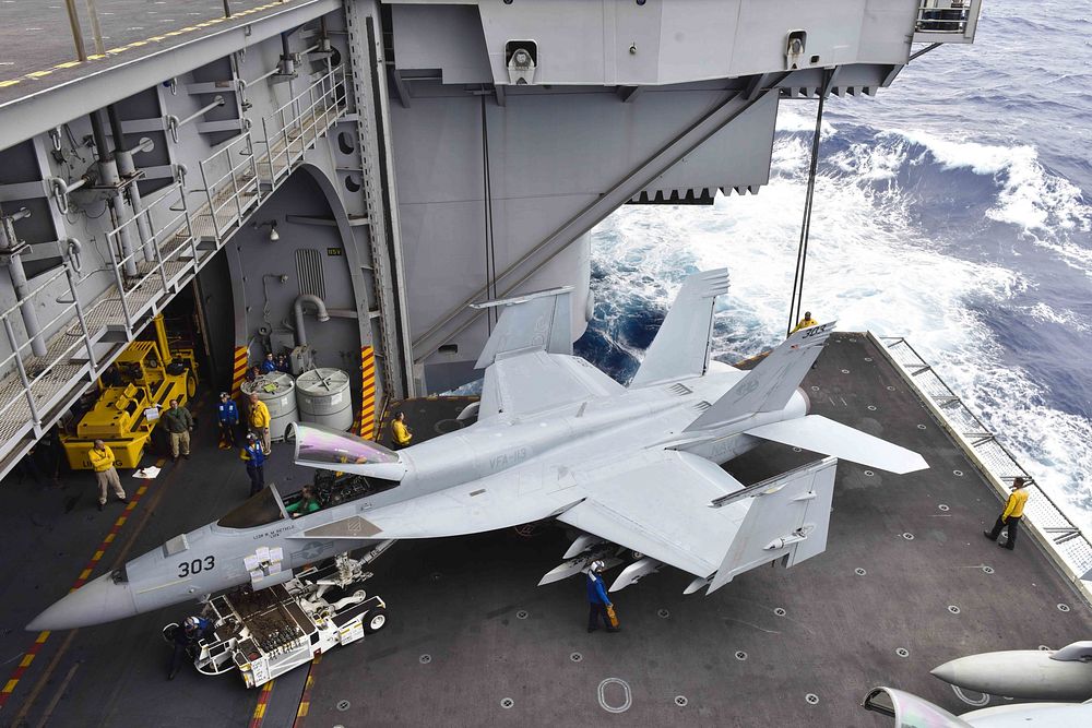 U.S. Sailors move an F/A-18E Super Hornet assigned to the Stingers of Strike Fighter Attack Squadron (VFA) 113 onto an…