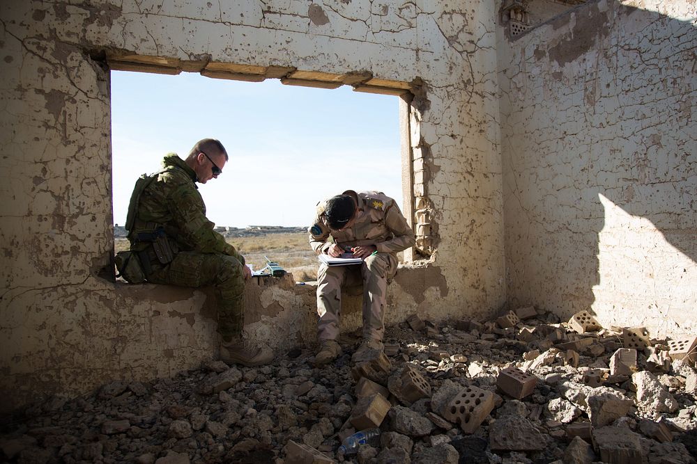 Australian trainer Sgt. Dave Devlin, (Left), assigned to the 4th Regiment, Royal Australian Artillery, waits for an Iraqi…