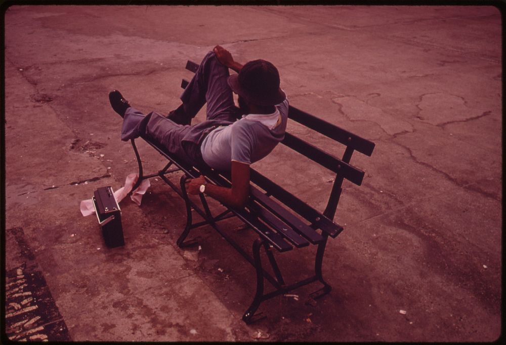 Man Lounging on a Park Bench with His Radio on the Reis Park Boardwalk in New York City. The Inner City Today Is an Absolute…