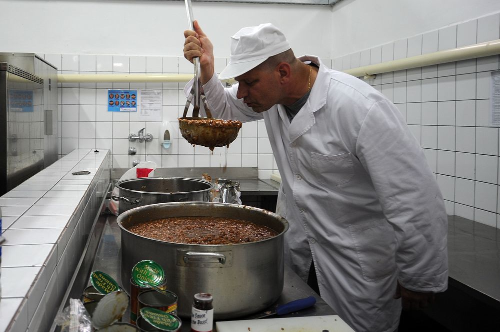 Troy Delfs, a civilian with 1st Combat Communications Squadron, Ramstein Air Base, Germany, checks a pot of baked beans…