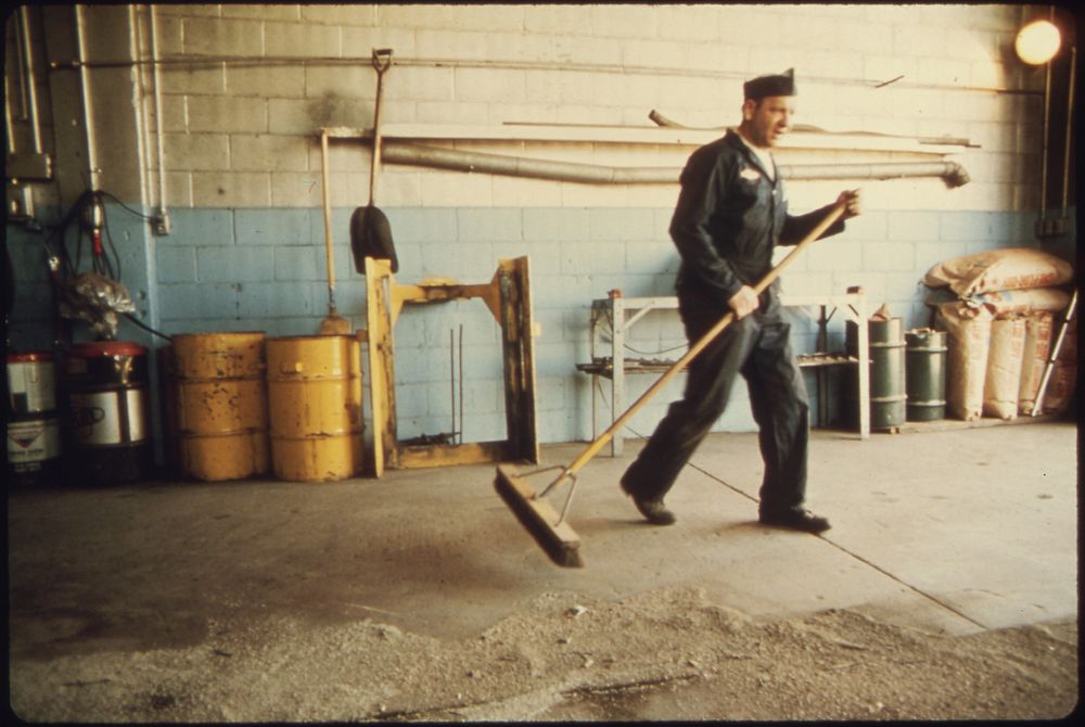 Wallace "Whitey" Wolf, a Mechanic for the City Sweeps Out the Repair Garage.
