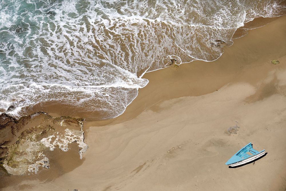 Half of a small, makeshift boat, or "yola," sits abandoned on a remote beach near Aguadilla, Puerto Rico, April 3, 2019.