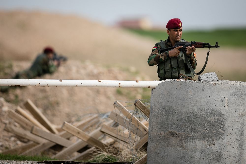 A coalition partner and security force member pulls security while participating in a simulated base defense near Erbil…
