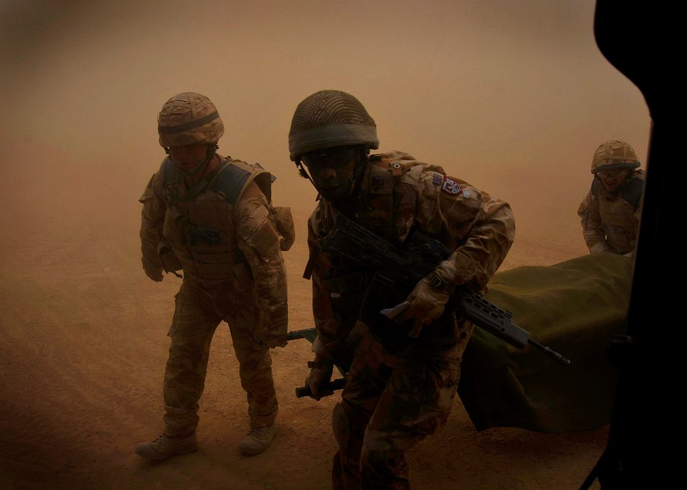 U.S. Air Force pararescuemen carry an injured patient after receiving him from coalition forces in the Helmand province of…