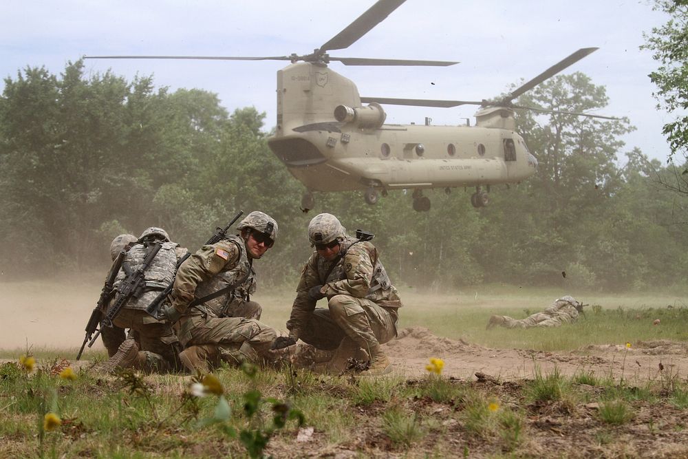 U.S. Soldiers with the 1194th Engineer Company take cover from the rotor wash of an Ohio Army National Guard CH-47 Chinook…