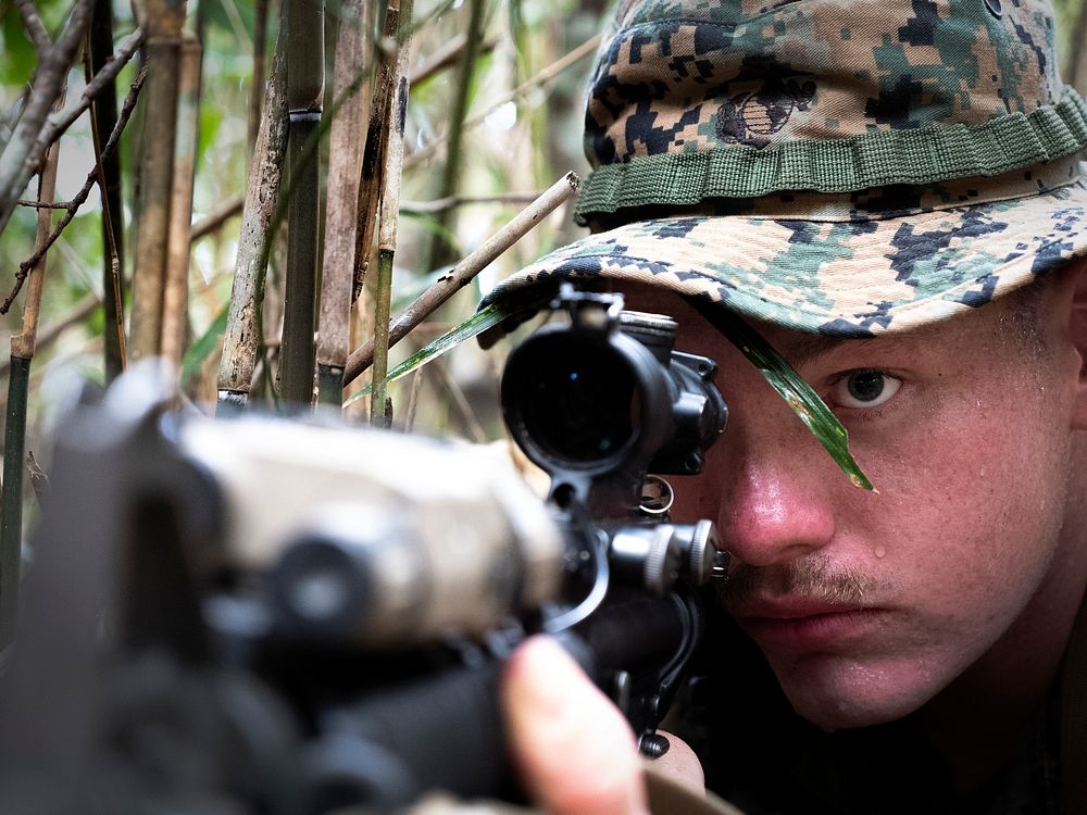 A U.S. Marine with Headquarters Company, Headquarters Battalion, 3rd Marine Division, sights in while posting 360-degree…
