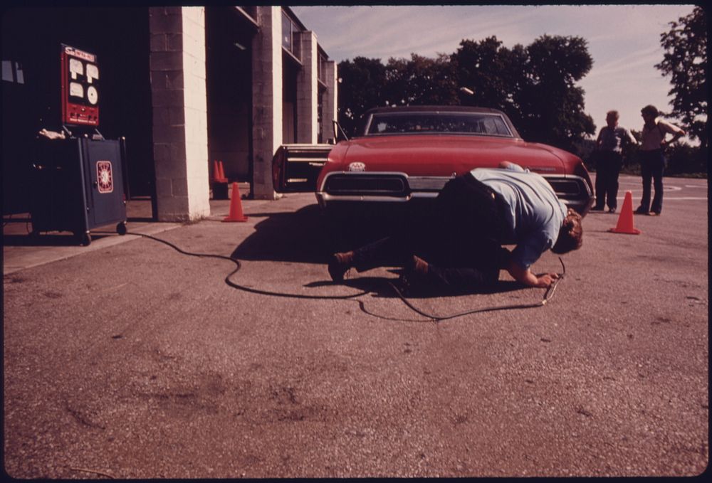 Employee at the Hamilton County Auto Emission Inspection Station at Newtown, Ohio. Checks the Exhaust System for a Leaking…