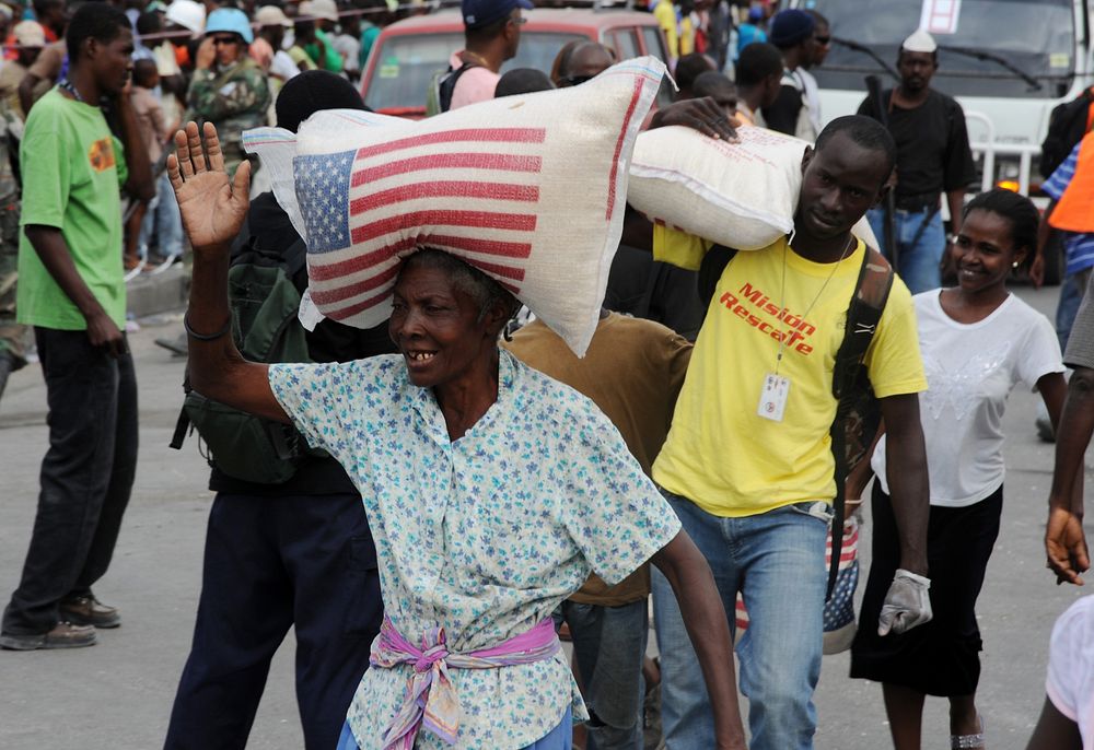 Earthquake victims in Haiti receive bags of rice from relief workers in front of the Presidential Palace in Port-au-Prince…